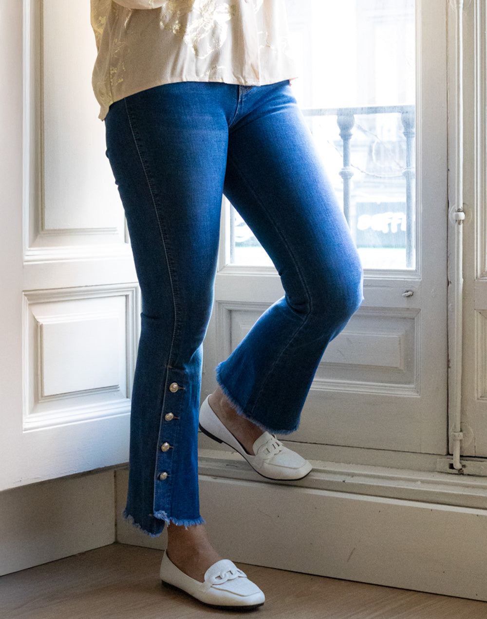Pantalón vaquero acampanado con botones dorados