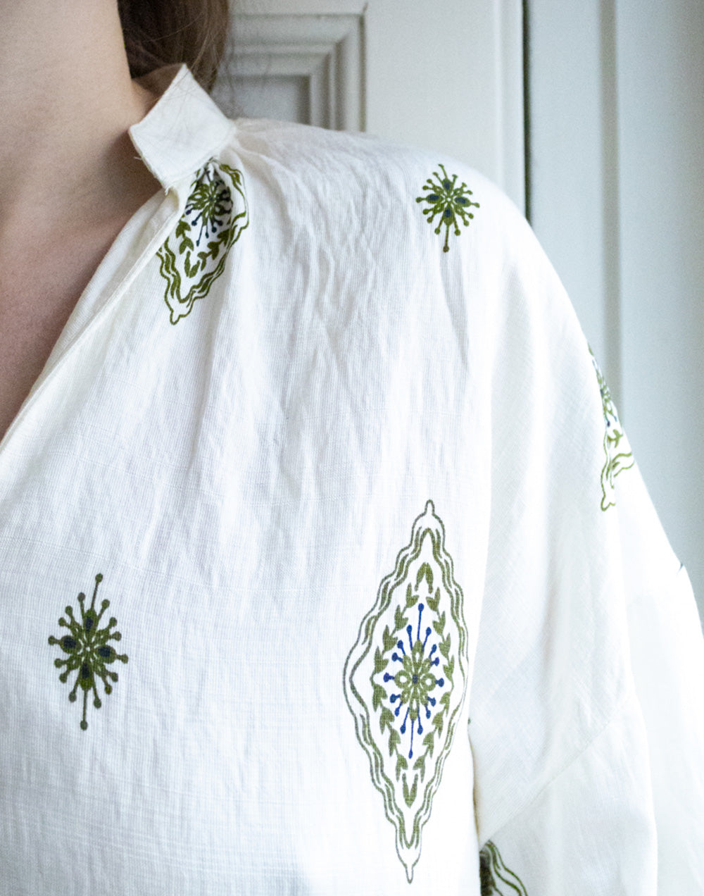 Camisa blanca étnica con motivos verde muestrarios de moda y ropa de mujer vestir
