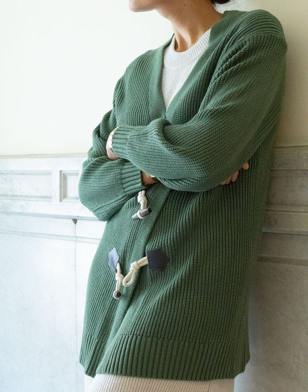 Chaqueta de tricot grueso verde con botones tipo trenca muestrarios de ropa y moda de mujer vestir bien en otoño dias de frio