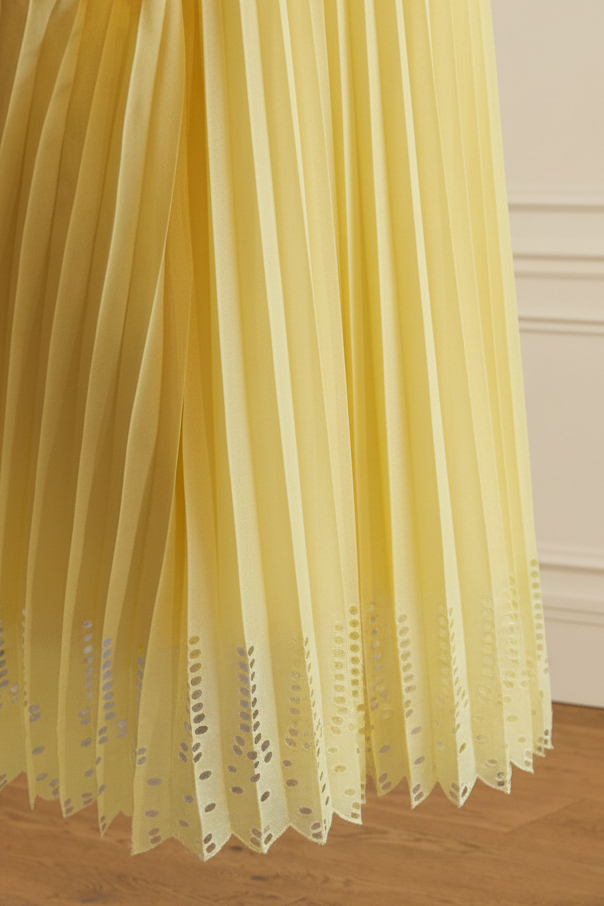Detalle bajo falda plisada amarillo calado geométrico