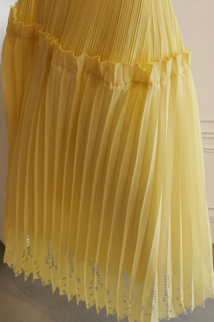 Detalle bajo falda plisada amarillo calado todo alrededor