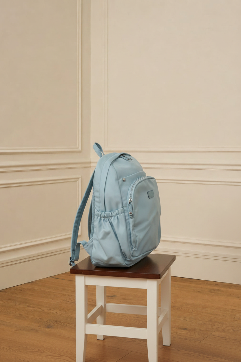 Mochila azul celeste - lateral en taburete
