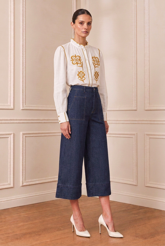 Modelo con camisa blanca bordada en amarillo mostaza