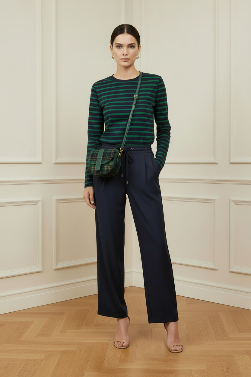 Modelo con camiseta de rayas marino y verde, pantalón marino y bolso de tartán verde