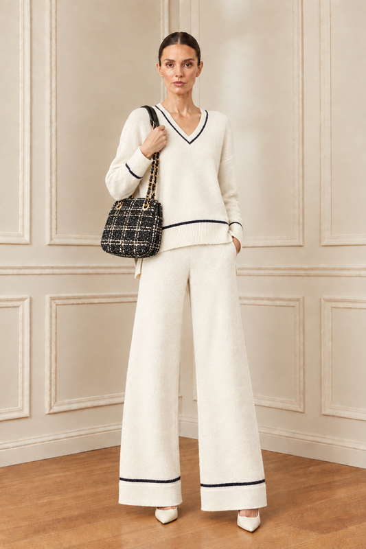 Modelo con conjunto de tricot sin collar y bolso de tweed con cadenas doradas