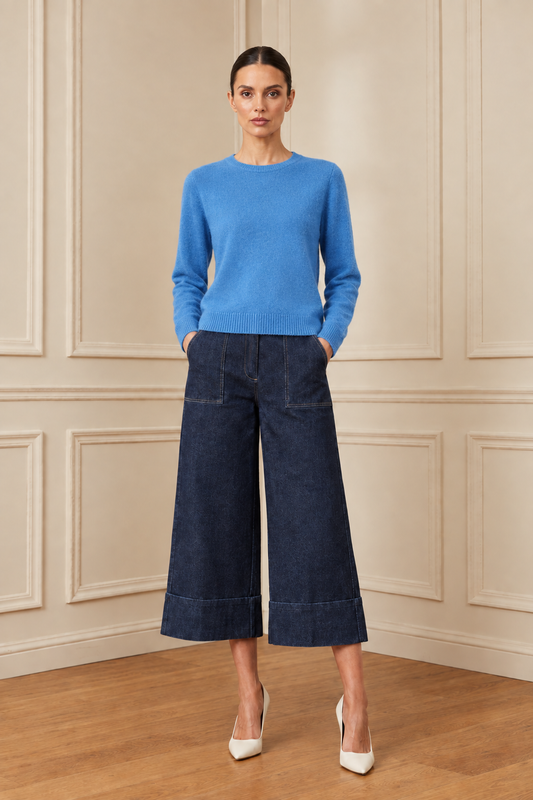 Modelo con jersey azul y el mismo pantalón denim en la estancia de molduras