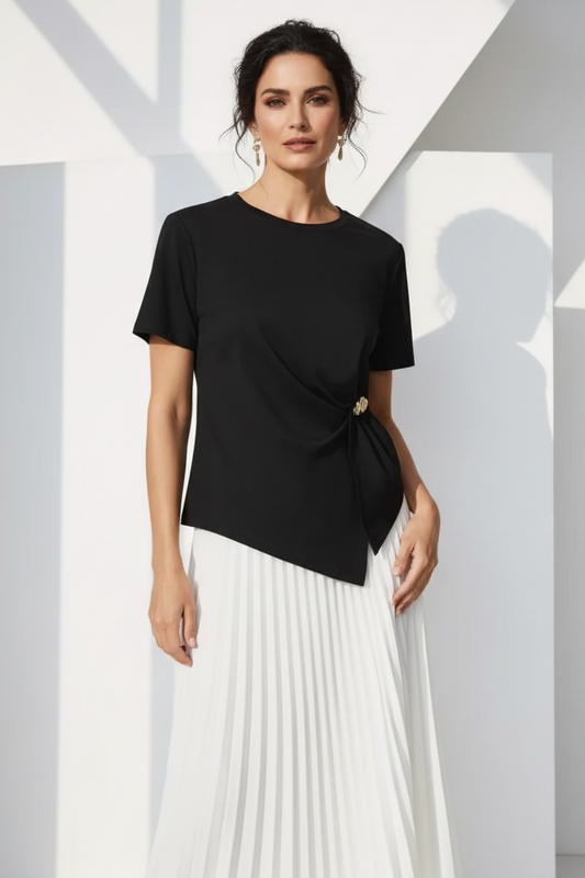 Modelo española con camiseta negra y falda plisada blanca